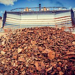 The wide blade of a bulldozer pushes together a large pile of ore that will be transported to the Crusher and then to the Heap Leach Pad for processing at the Moss Mine.